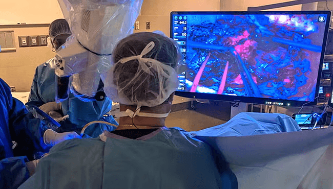 Tumor tissue fluorescing under blue light during surgery